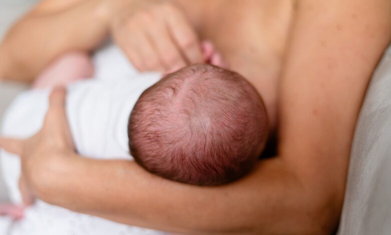 Mãe amamenta bebê durante período de aleitamento materno