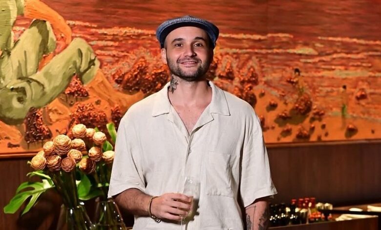 Artista paraibano Pedro Delgado ao lado de suas pinturas